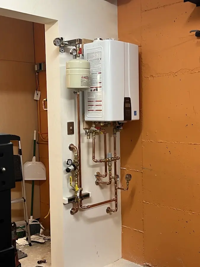Plumbing technician inspecting water heater connections in Valdese